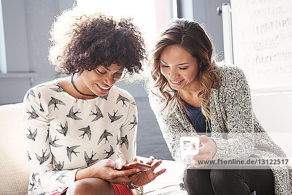 Geschäftsfrauen mit Mobiltelefon im Büro