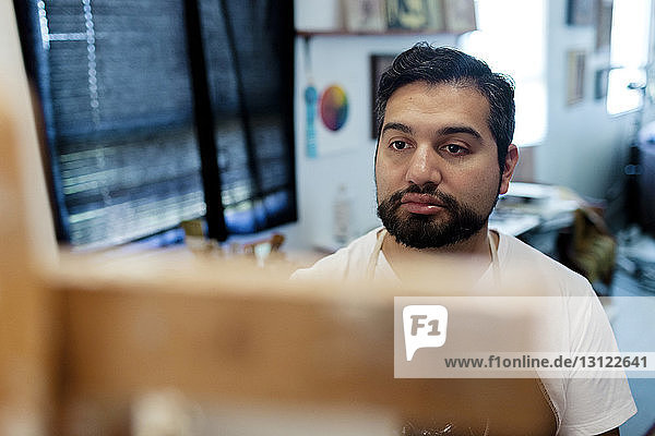 Painter looking at easel in art studio