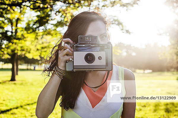 Junge Frau fotografiert mit Oldtimer-Kamera