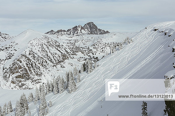 Landschaftliche Ansicht der Skipiste vor schneebedeckten Bergen