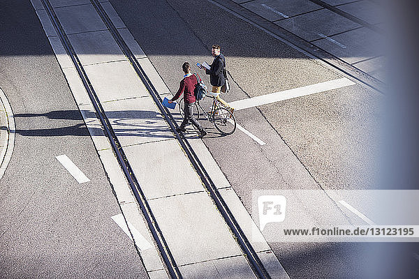 Hochwinkelansicht von Freunden  die mit dem Fahrrad auf der Straße unterwegs sind