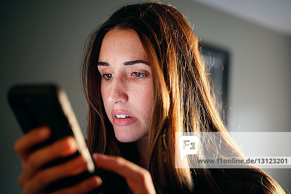 Nahaufnahme einer Frau  die zu Hause ein Smartphone benutzt