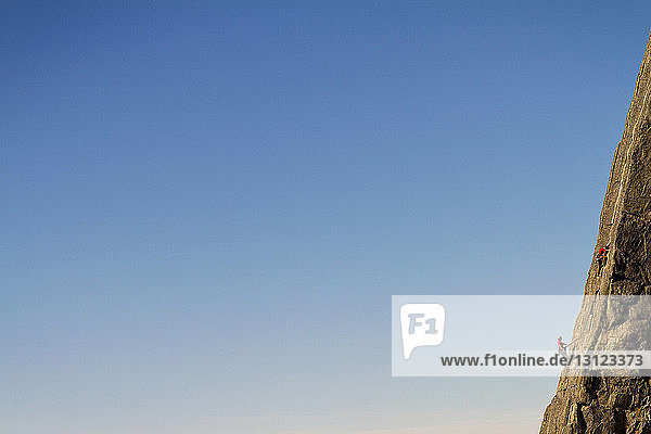 Fernsicht von Bergsteigern beim Bergsteigen vor klarem blauen Himmel