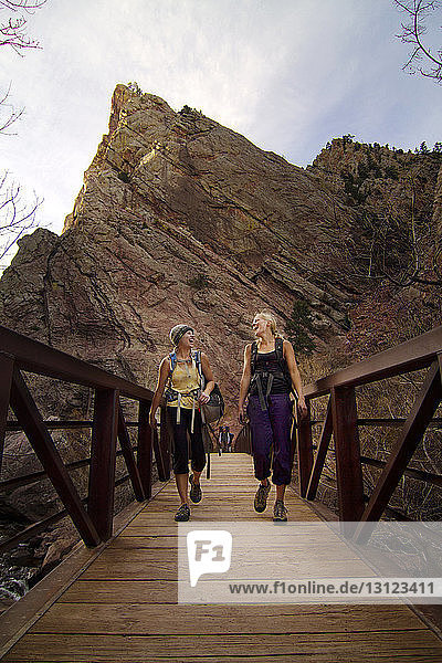 Freundinnen gehen auf Brücke gegen Berg