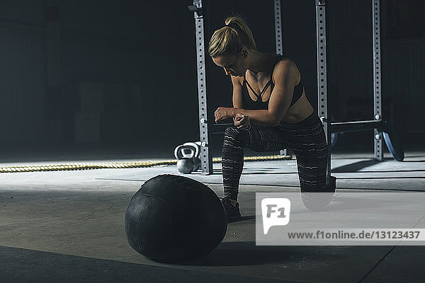 Female athlete exercising by fitness ball in gym