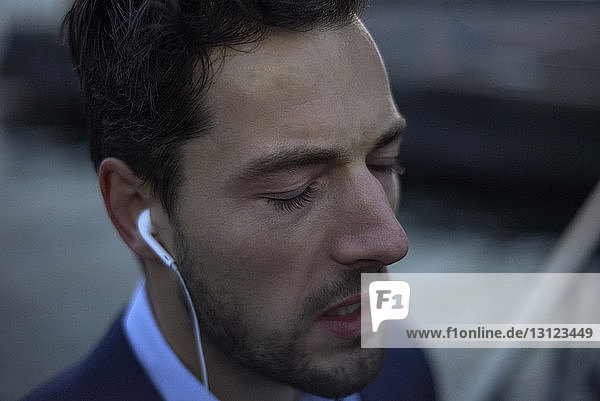 Close-up of businessman with eyes closed listening music