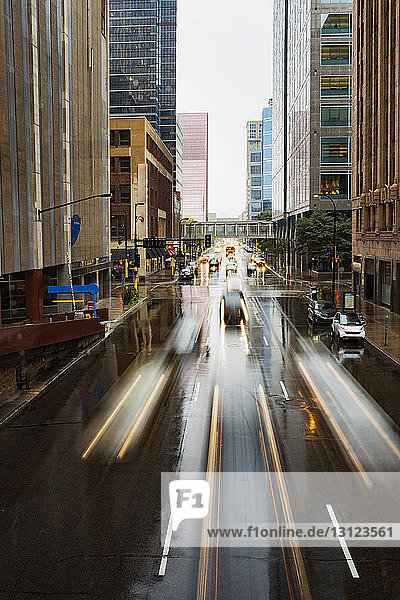 Long exposure of vehicles moving on city street during rainy season