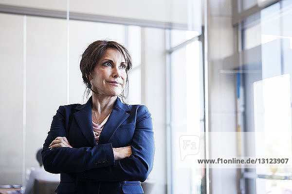 Thoughtful businesswoman standing in office