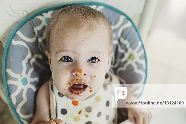 Portrait of cute baby girl with food messed on her face