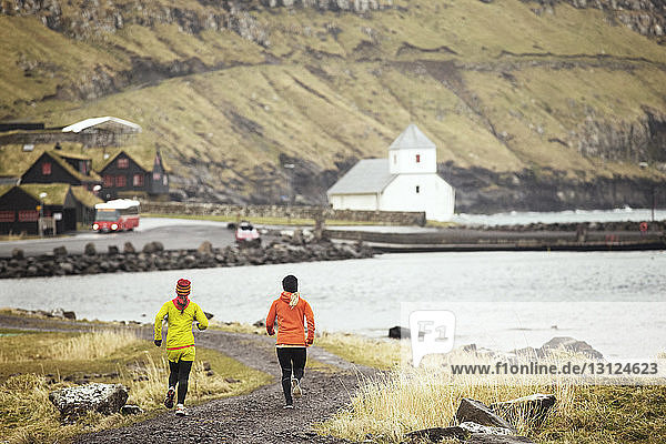 Freunde joggen an der felsigen Küste entlang