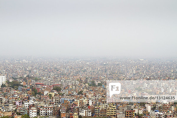 Luftaufnahme des Stadtbildes bei Nebelwetter gegen den Himmel