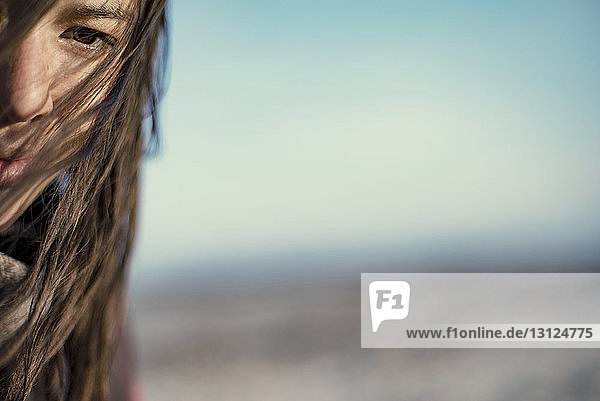 Ausgeschnittenes Bild einer Frau mit zerzaustem Haar gegen den Himmel