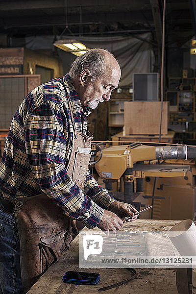 Senior-Handwerker suchen Werkzeuge in der Werkstatt