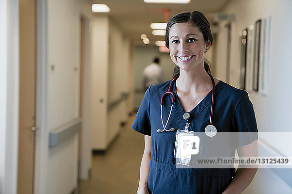 Porträt einer fröhlichen Ärztin  die in der Krankenhauslobby steht