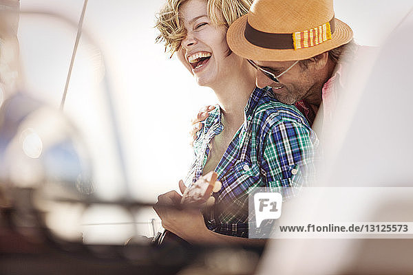 Smiling couple enjoying at boat on sunny day