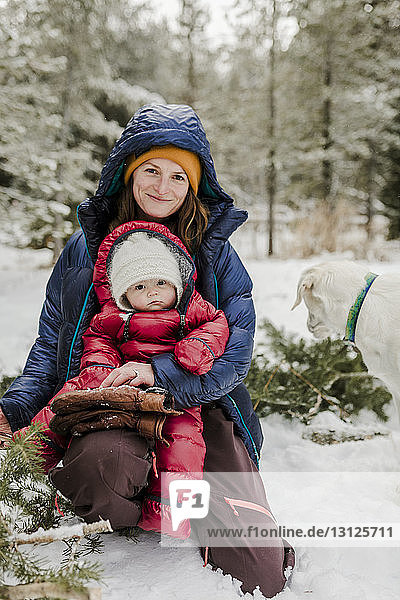 Portrait of mother with daughter in forest during winter