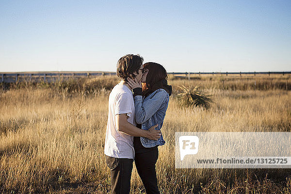 Seitenansicht eines zärtlichen Paares  das sich auf dem Spielfeld küsst