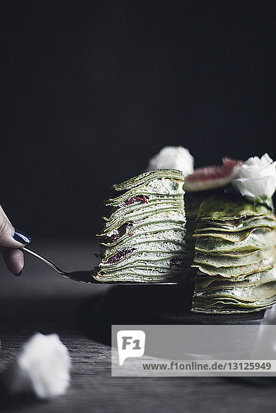 Ausgeschnittenes Bild einer Frau  die eine Scheibe Pfannkuchen entfernt