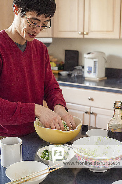Mann bereitet zu Hause in der Küche das Essen vor