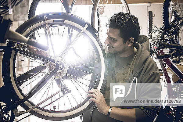 Männlicher Kunde untersucht Fahrradreifen  während er im Geschäft steht