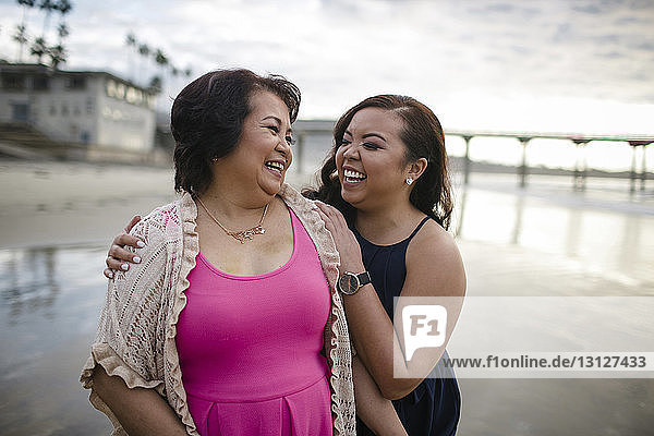 Cheerful mother and daughter at beach