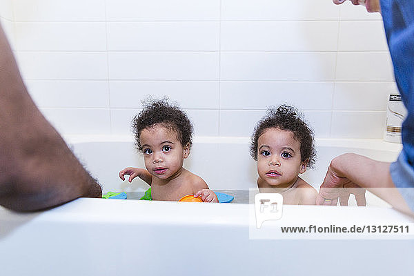 Ausgeschnittenes Bild von Eltern  die ihre Töchter gemeinsam in der Badewanne baden