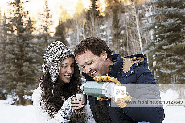 Man pouring coffee for wife in cup