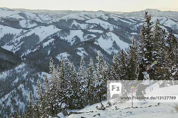 High angle view of man skiing on snow covered mountain during sunset