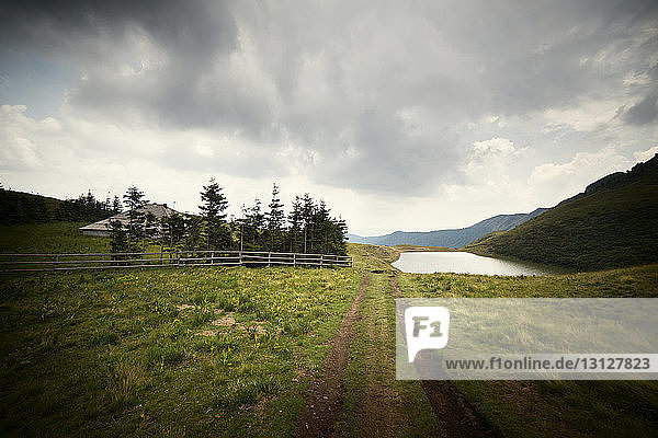 Scenic view of grassy field against cloudy sky
