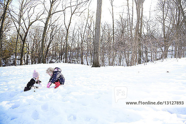 Sisters playing on snow covered field