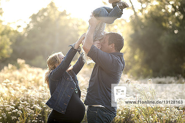Seitenansicht einer glücklichen Familie auf dem Feld an einem sonnigen Tag