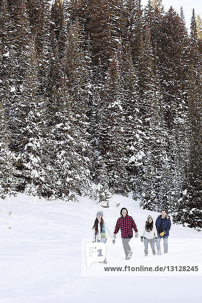 Happy family walking on snowy field