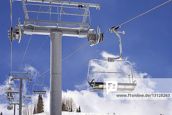 Low angle view of ski lifts against sky