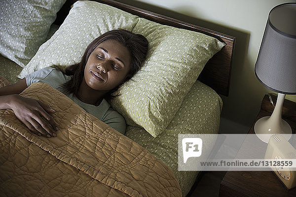 Frontansicht einer Frau  die zu Hause auf dem Bett schläft