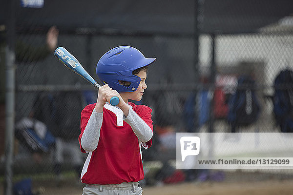 Junge spielt Baseball auf Sportplatz