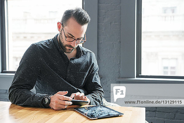 Geschäftsmann mit Tablet-Computer am Schreibtisch im Büro