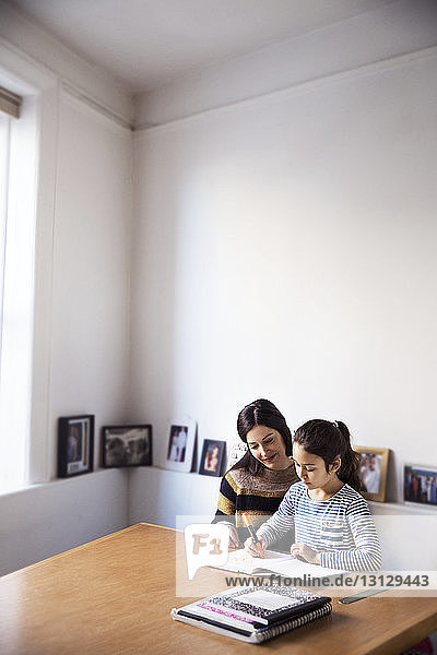 Mother looking at girl studying