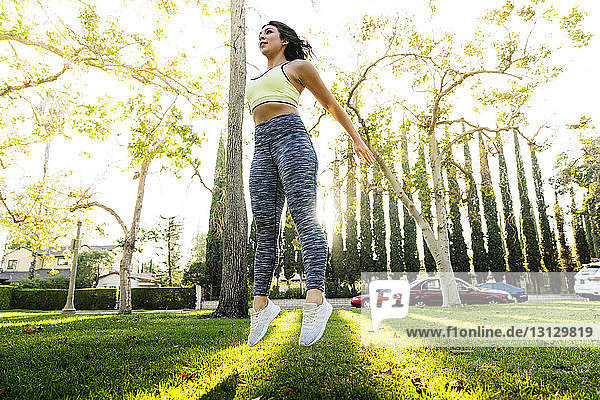 Woman jumping while exercising in park