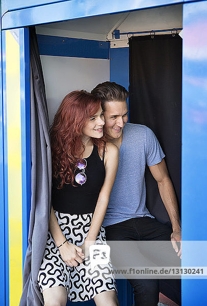 Junges Paar sitzt lächelnd in der Fotokabine