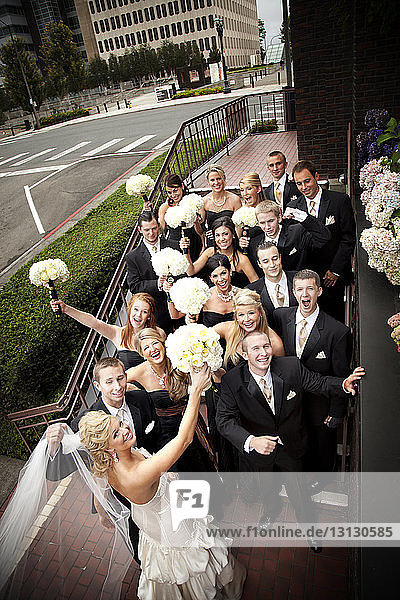 Hochwinkelansicht von Freunden und Familie mit Braut und Bräutigam auf der Treppe