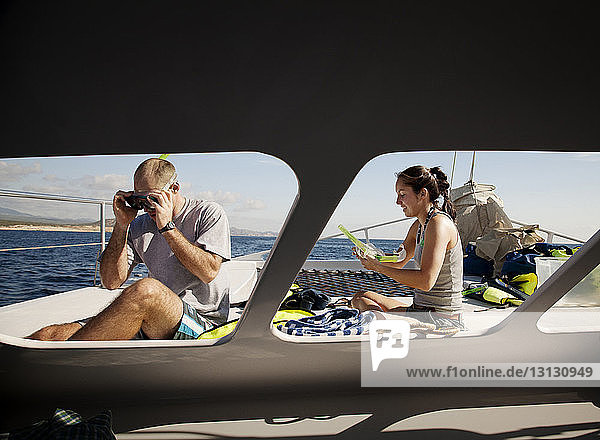 Ehepaar  das sich auf das Tauchen vorbereitet  während es an Deck des Bootes sitzt