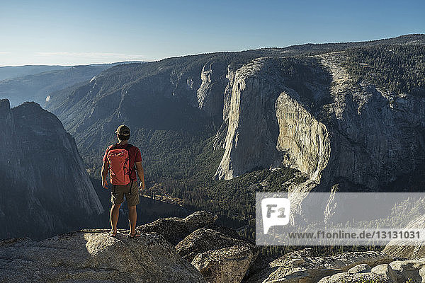 Rückansicht eines männlichen Wanderers  der auf einer Klippe im Yosemite National Park steht