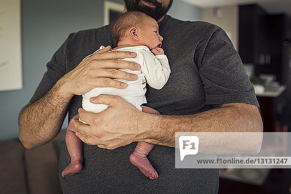 Mittelsektion des Vaters mit neugeborenem Jungen zu Hause
