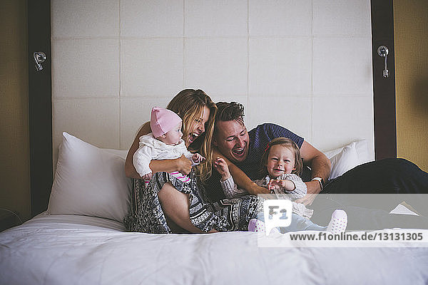 Happy family having fun on bed at home