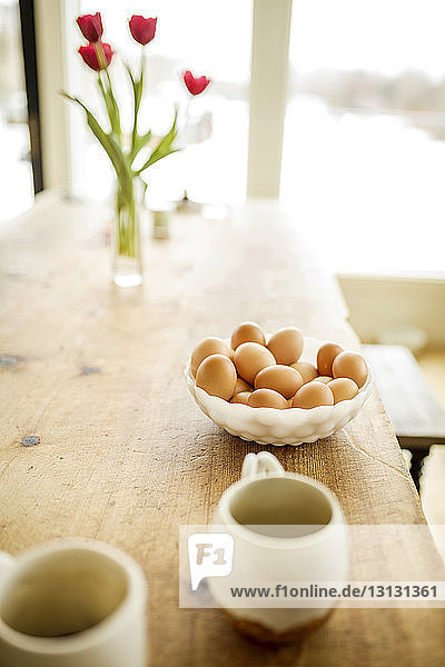 Nahaufnahme von Eiern in der Schale durch Tassen auf dem heimischen Tisch