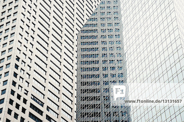Niedrigwinkelansicht eines modernen Gebäudes  das an Fenstern reflektiert wird