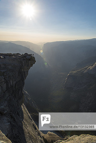 Fernansicht eines Mannes  der bei Sonnenschein auf einem Berg im Yosemite National Park steht