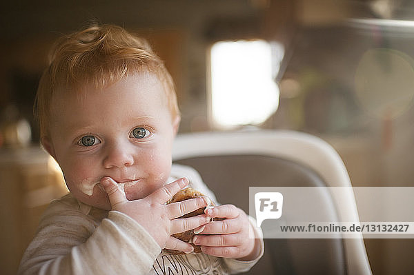 Porträt eines süßen kleinen Jungen,  der zu Hause isst