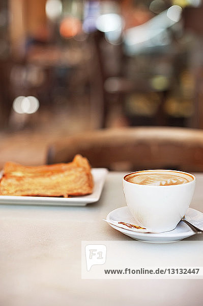 Cappuccino und Gebäck auf dem Tisch im Café serviert
