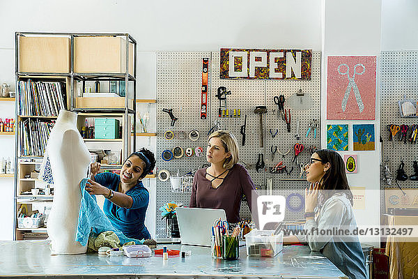 Modedesigner arbeiten an Schaufensterpuppe im Kreativbüro